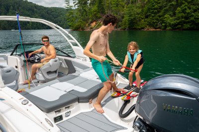 Chaparral 21 SSi OB two children learning to waterski while adult looks on. 