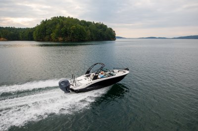 Chaparral 21 SSi OB Ski & Fish with one person cruising on a lake. 