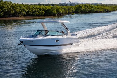 Chaparral 270 OSX cruising on water with buildings in the background 