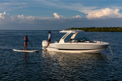 Chaparral 270 OSX on water while one person paddleboards and another looks on 