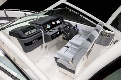 Chaparral 280 OSX helm area with cabin door, wide captain's chair, and Simrad displays. 