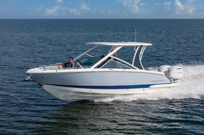 Chaparral 280 OSX with two people riding in the bow front port view. 