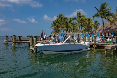 Chaparral 280 OSX docked at a restaurant with passengers boarding. 
