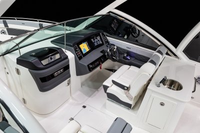 Chaparral 310 OSX helm area with cabin door, captain's chair, and in-floor storage. 