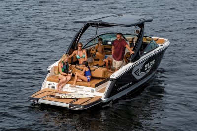 Chaparral 28 SURF floating on a lake with some kids getting ready to surf. 